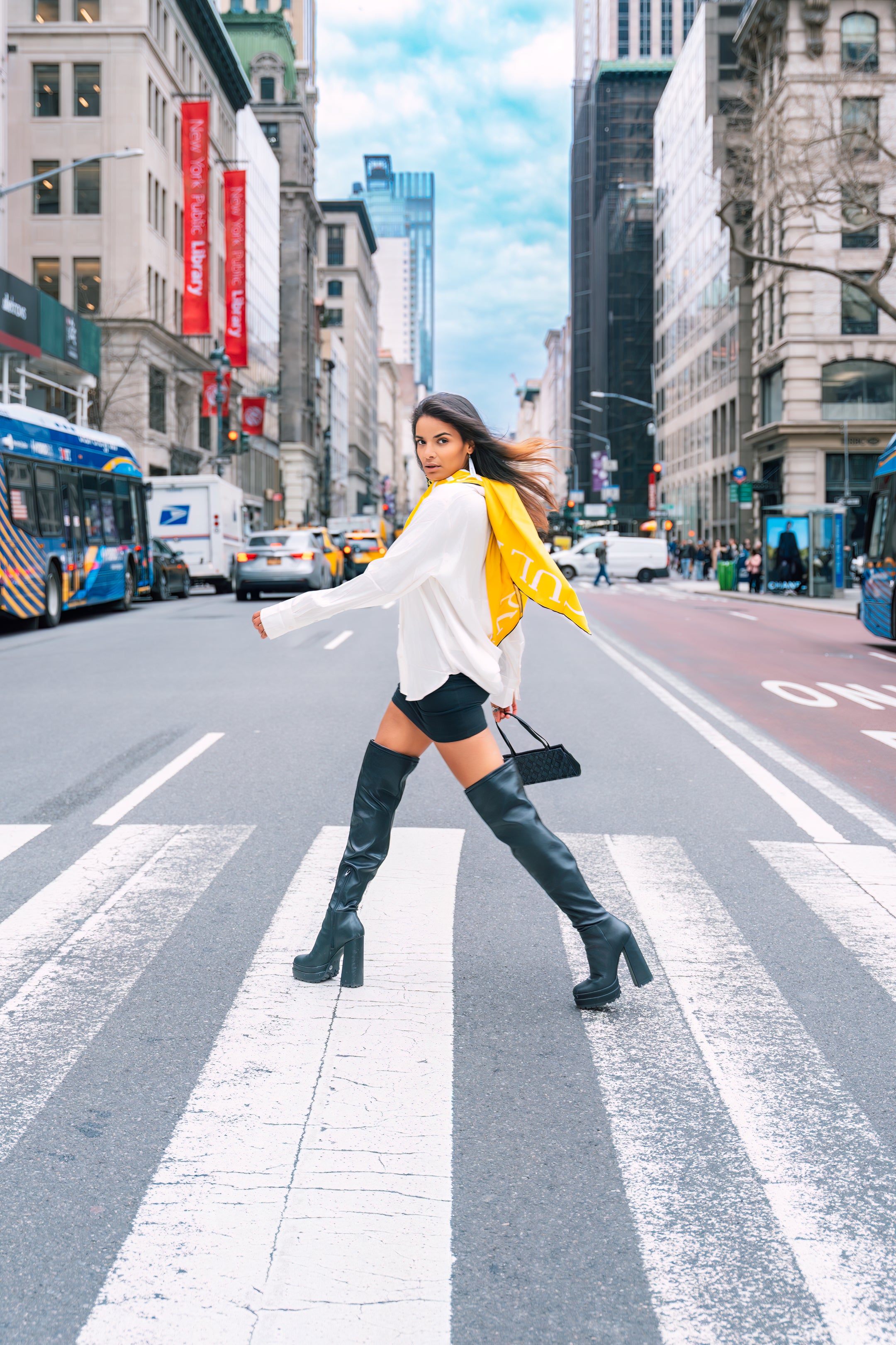 Model wearing a Cult Luxury silk scarf, walking confidently in an urban setting. Showcasing rebellious elegance and high-fashion style in silk artwear