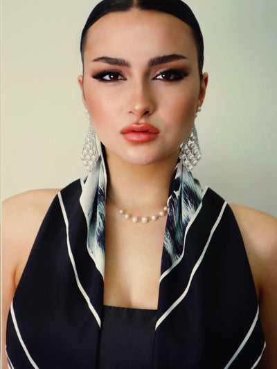 Model wearing Black Snow Leopard scarf close-up, showcasing luxury animal print detail and silk texture.