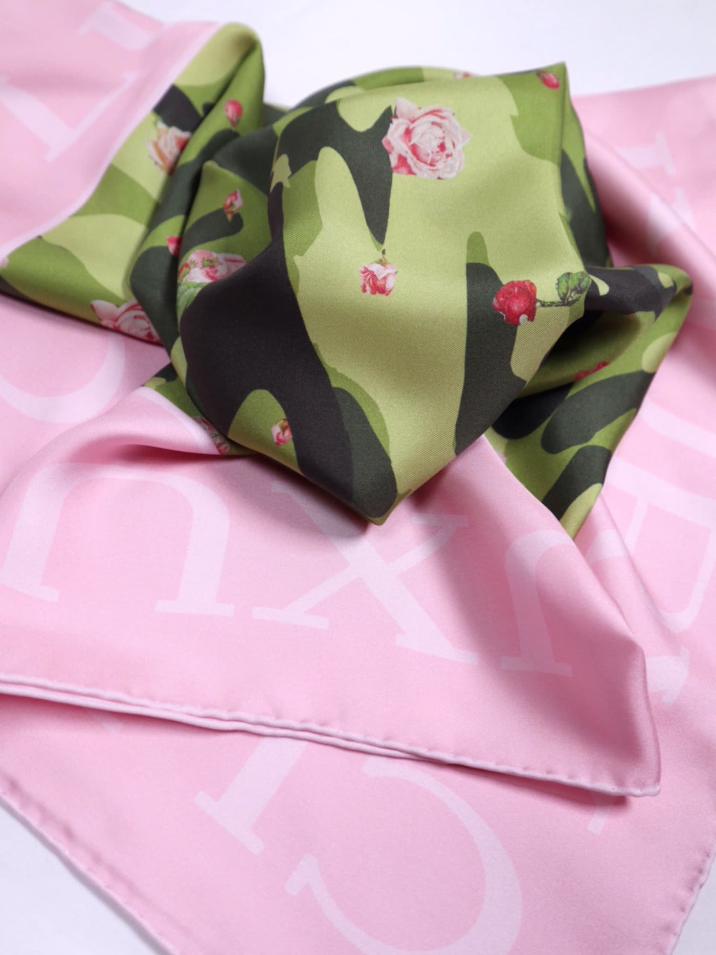 Close-up of Cult Luxury’s Floral Camo Pink silk scarf, showcasing vibrant green camo and delicate pink rose details with soft pink border.