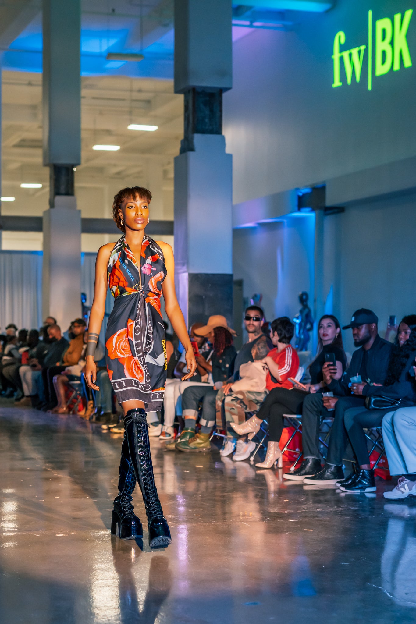 Model walking the runway wearing the Pink Roses Shawl from Cult Luxury, styled as a striking accessory with contrasting pink florals and black silhouettes.