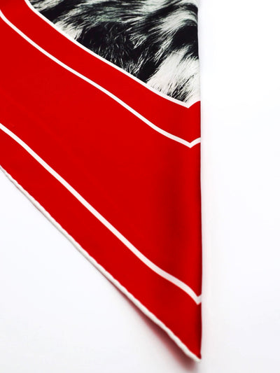 Edge detail of the Red Snow Leopard 90 silk scarf with red borders and hand-rolled edges from Cult Luxury’s Gala Collection.