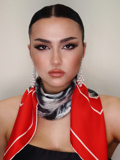 Model close-up wearing the Red Snow Leopard 90 silk scarf from Cult Luxury’s Gala Collection, showcasing a luxurious red frame with leopard print.