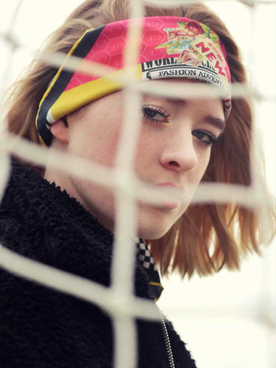 Model wearing the Butterfly Season luxury silk scarf 65 as a headscarf, featuring hand-rolled edges, bold red, yellow, and black hues, and Cult Luxury’s signature accessory design.