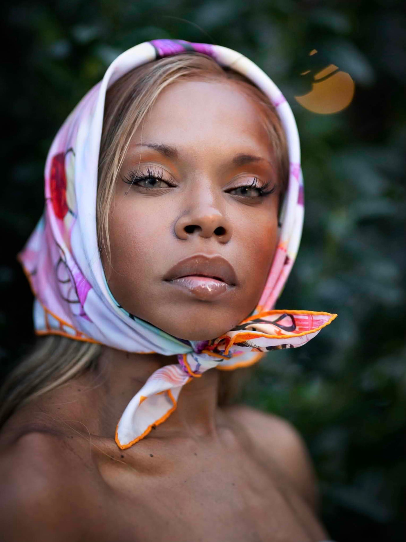 Model wearing the “Humdinger 65” luxury silk scarf as a head wrap, showcasing the vibrant purple, orange, and red brushstroke design with elegant draping.