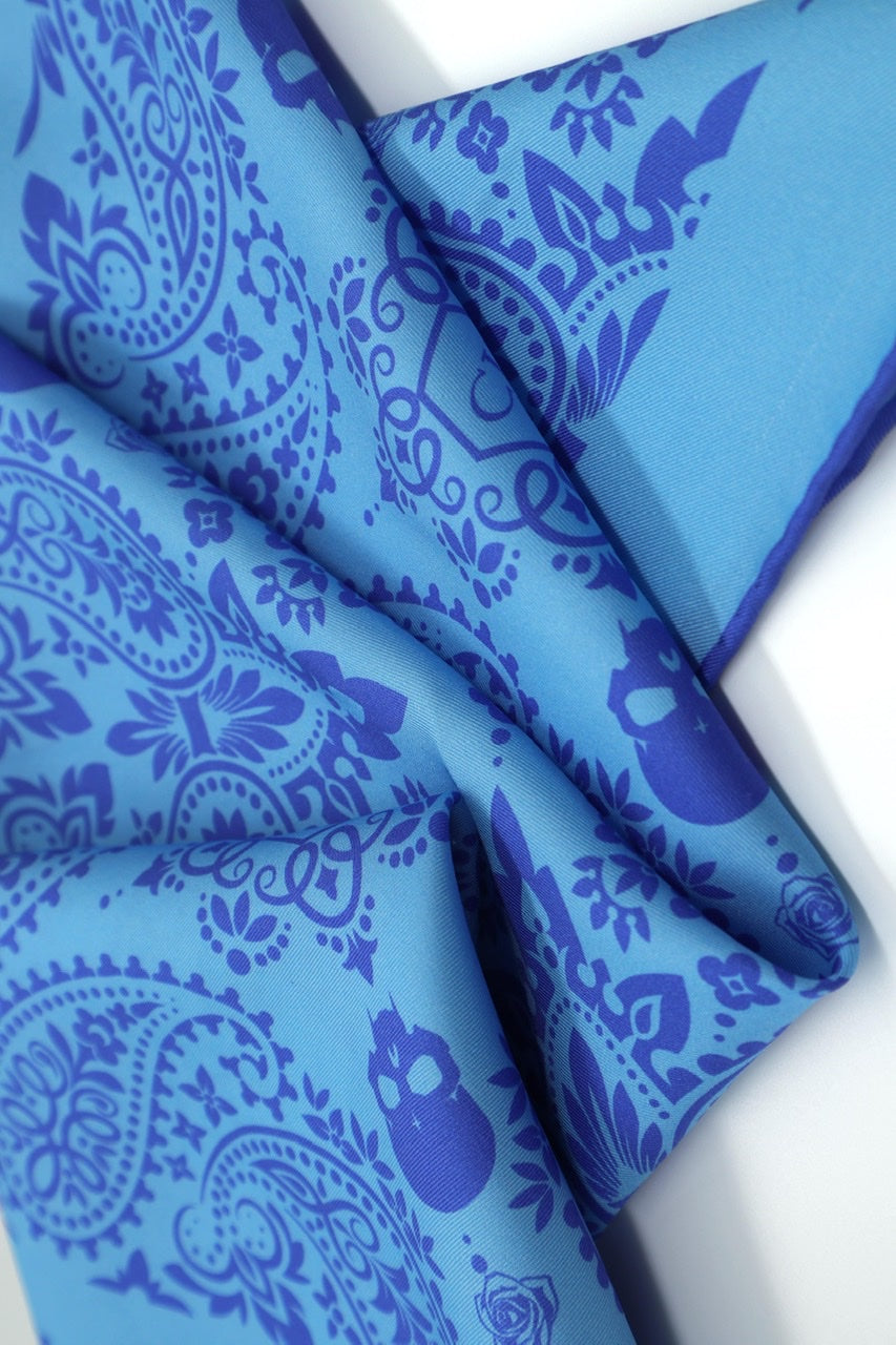 Close-up of Cult Luxury Baby Blue Silk Bandana fabric with intricate floral pattern, showcasing the fine silk texture and vibrant blue color